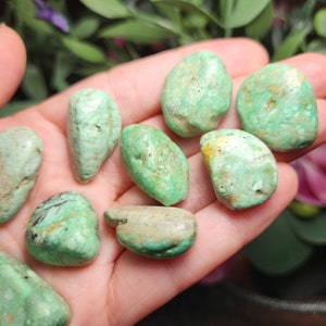 May include: A collection of eight green and white tumbled stones. The stones are smooth and have a variety of patterns.
