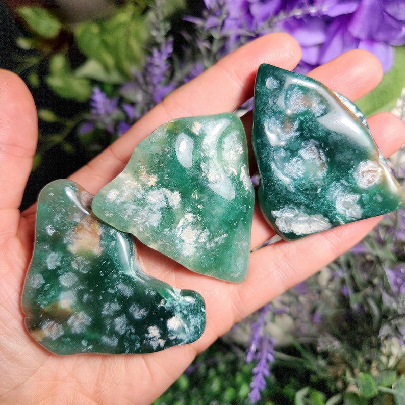 May include: Three green and white agate stones with a mottled pattern. The stones are smooth and polished.