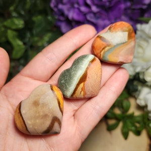 May include: Three heart-shaped polished stones with brown, orange, green, and white patterns.