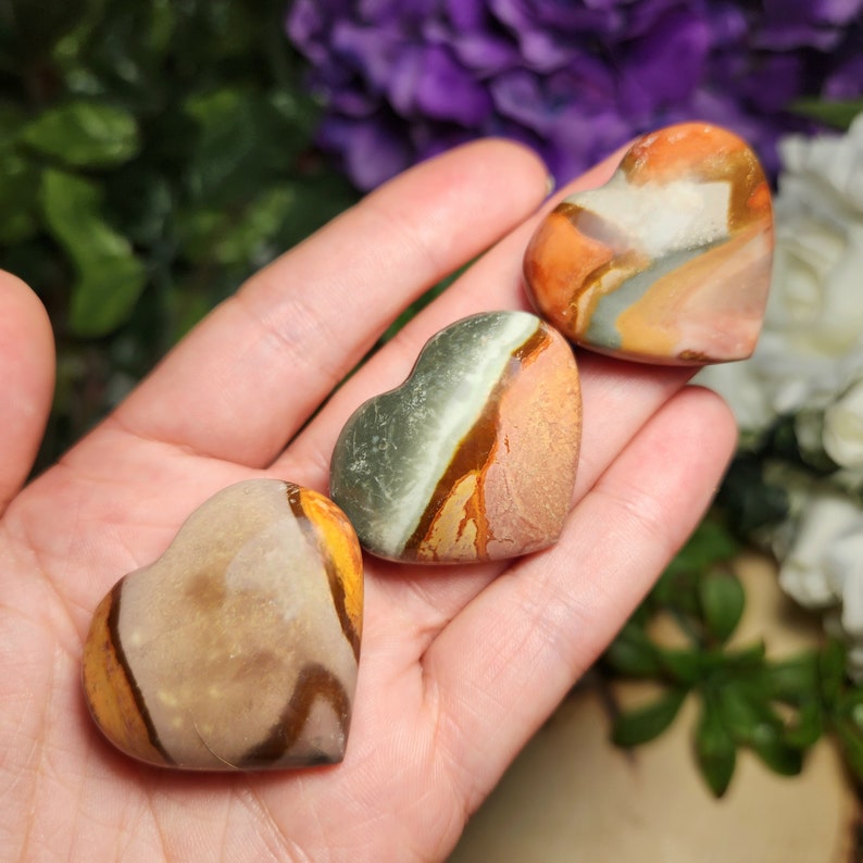 May include: Three heart-shaped polished stones with brown, orange, green, and white patterns.