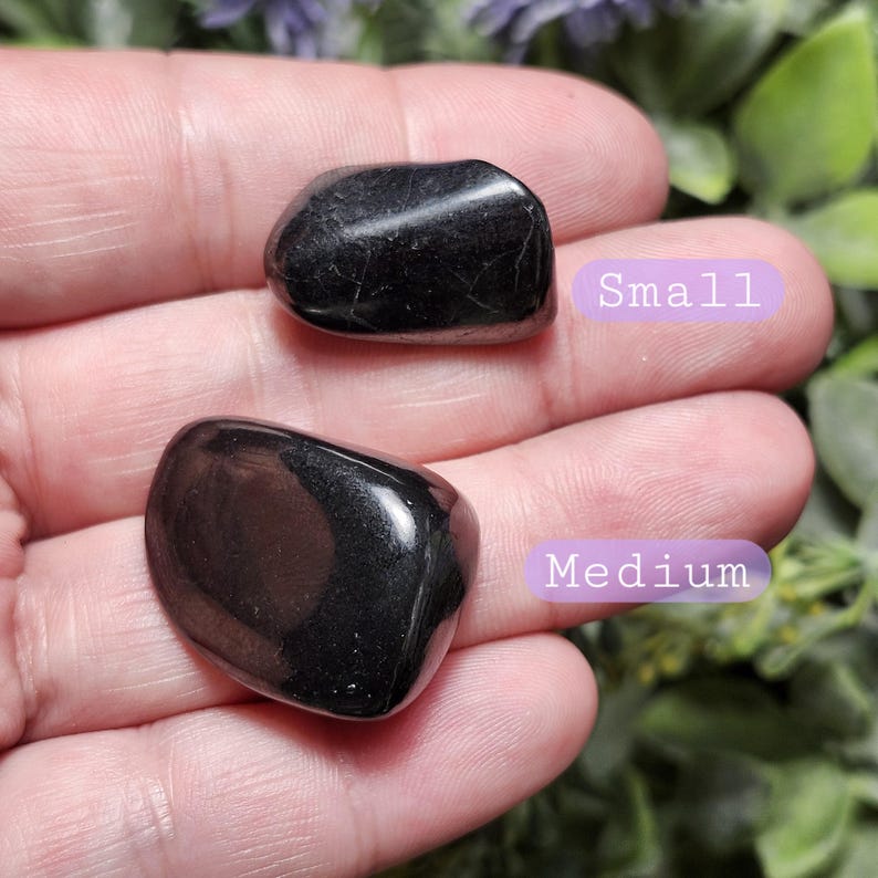 May include: Two black tumbled stones, one labeled "Small" and the other labeled "Medium".