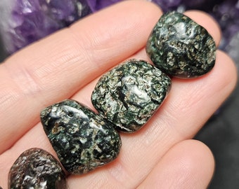May include: Four tumbled green and black serpentine stones with a speckled pattern.