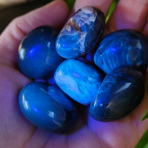 May include: A collection of six blue and white tumbled stones. The stones are smooth and polished, and they have a variety of patterns and textures.