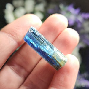 May include: A blue and green kyanite crystal point with striations and a pointed tip.