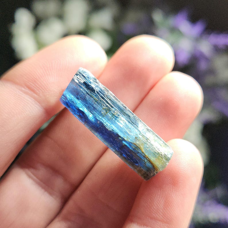 May include: A blue and green kyanite crystal point with striations and a pointed tip.