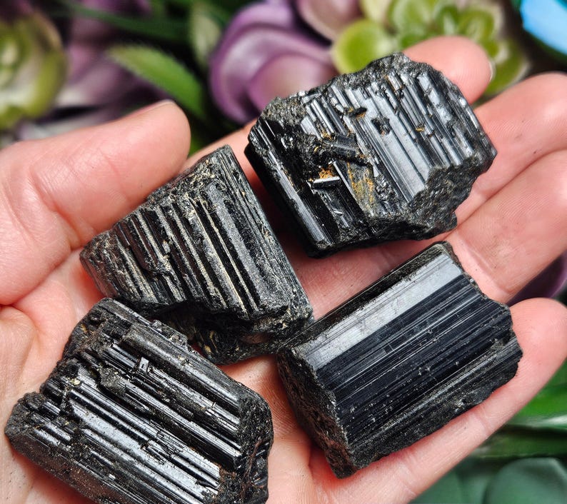 Peut inclure: Trois cristaux de tourmaline noire brute pr&eacute;sentant des stries verticales distinctes et une texture de surface sombre et brillante. Ces sp&eacute;cimens min&eacute;raux naturels ont des bords irr&eacute;guliers et une couleur noire opaque et profonde.