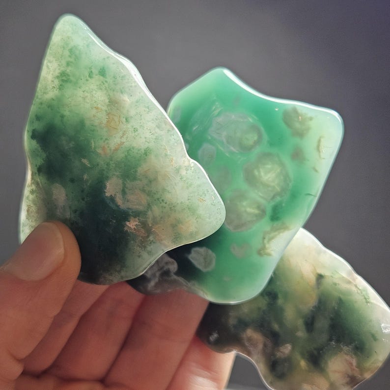 May include: Three green agate stones with a variety of patterns and textures. The stones are smooth and polished.