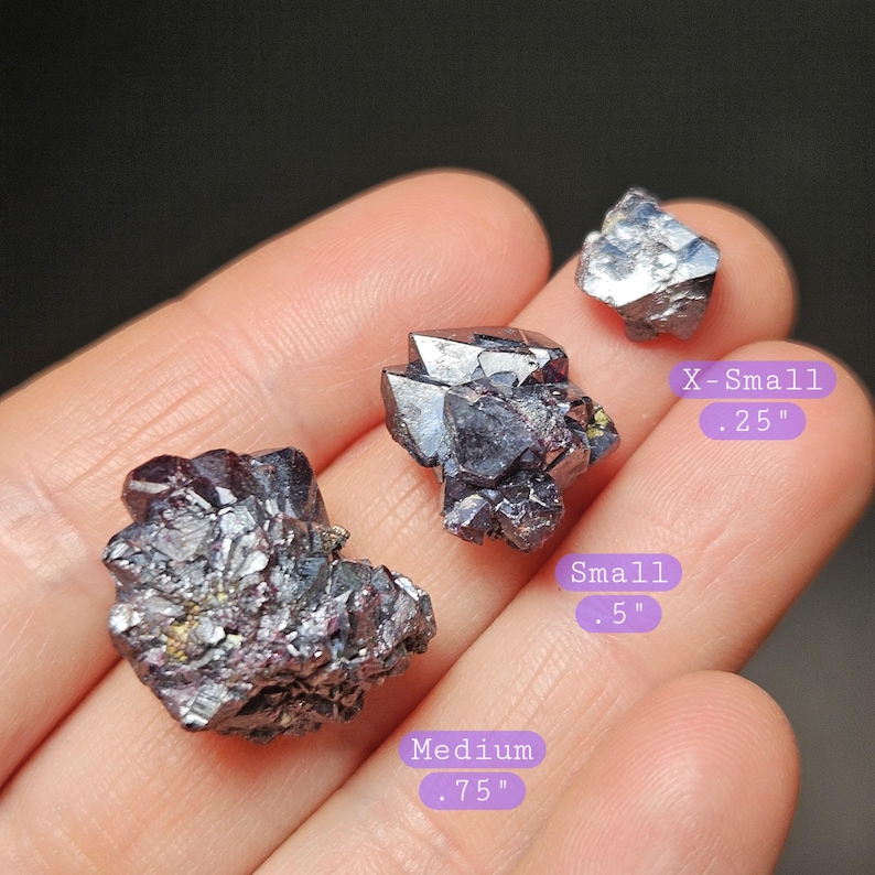 Puede incluir: Se muestran tres espec&iacute;menes minerales oscuros y met&aacute;licos de varios tama&ntilde;os. El m&aacute;s peque&ntilde;o est&aacute; etiquetado como "X-Small .25", el mediano como "Medium .75" y el m&aacute;s grande como "Small .5". Los minerales tienen una estructura cristalina.