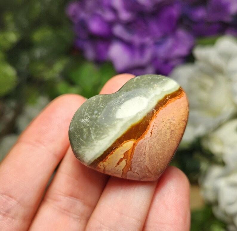 May include: A heart-shaped polished stone with brown, green, and white patterns.