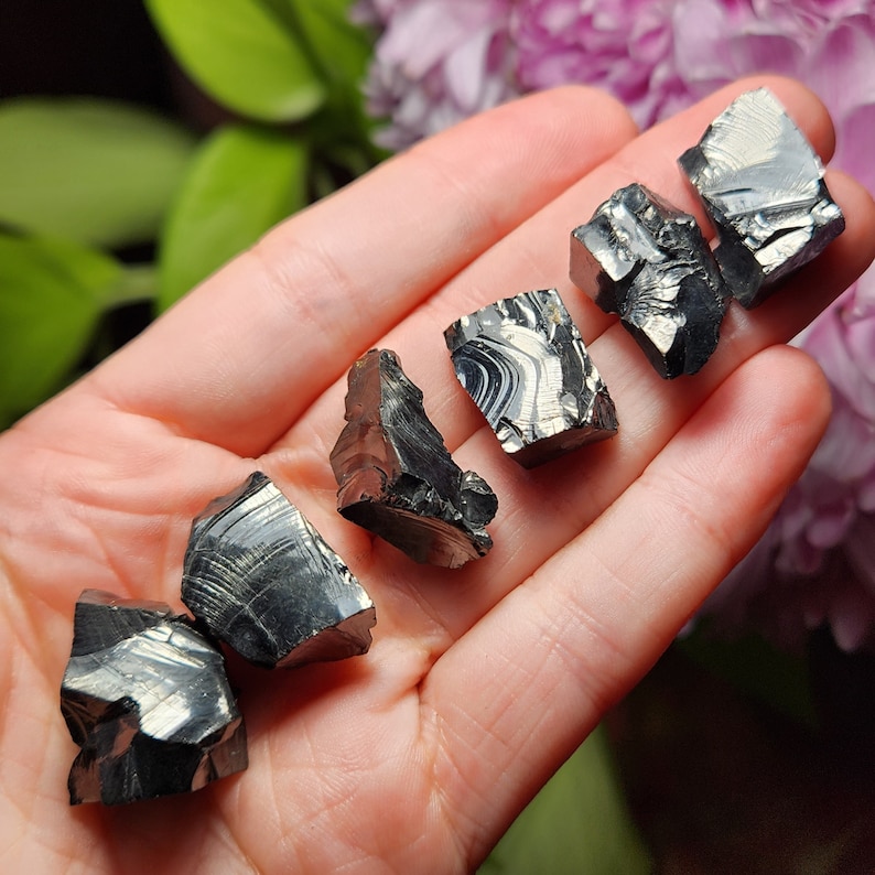 May include: Six black and silver iridescent obsidian stones of various shapes and sizes