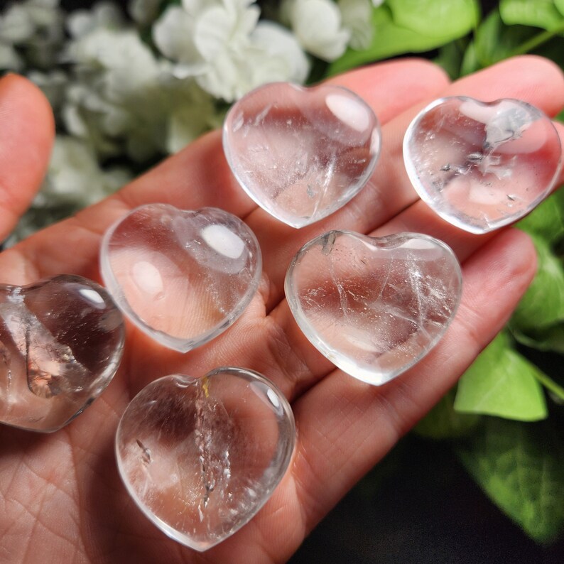 May include: Six clear quartz crystal heart shaped stones. The stones are smooth and polished.