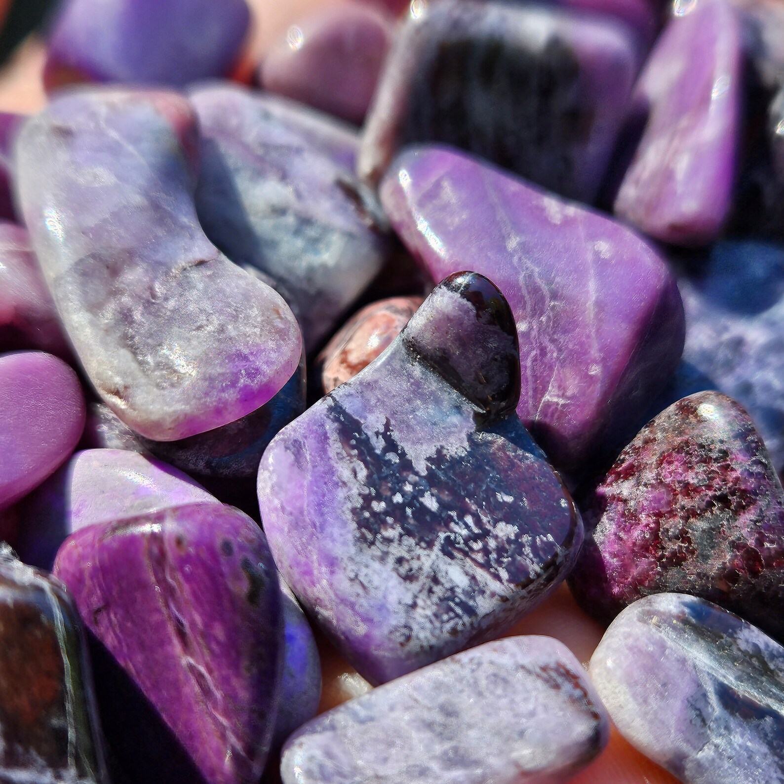 Polished sugilite tumbled stones in rich purple tones, ideal crystal for emotional balance and spiritual harmony.