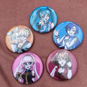 Könnte beinhalten: Fünf runde Ansteckbuttons mit Illustrationen von Anime-Charakteren. Die Buttons sind in Blau-, Rosa-, Orange- und Rottönen gehalten und haben eine glänzende Oberfläche. Jeder Button zeigt einen anderen Charakter mit einzigartigen Frisuren und Outfits.