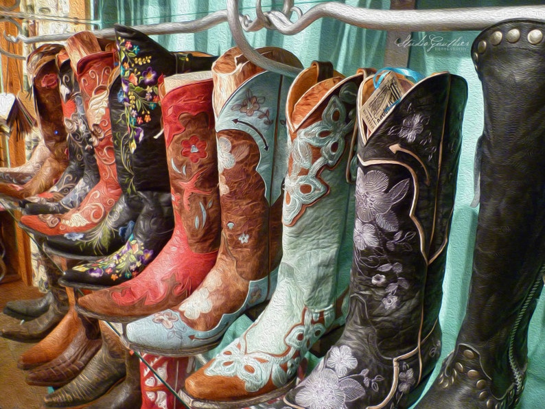 May include: A collection of colorful embroidered cowboy boots with floral designs. The boots are arranged in a row, with the toes pointing towards the viewer. The boots are all different colors, including red, blue, green, and brown. The boots are all decorated with intricate embroidery, featuring flowers, leaves, and other designs.