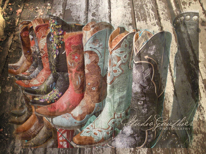 May include: A row of intricately embroidered cowboy boots in various colors, including brown, red, blue, and black, with floral and butterfly designs. The boots are arranged on a weathered wooden surface with the text "Studio Gauthier Photography" at the bottom.