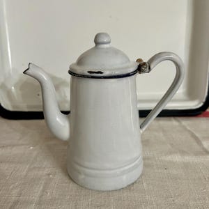 May include: A set of three ceramic vases in varying heights. The vases have a matte finish in shades of cream, beige, and brown. The tallest vase is approximately 10 inches high.