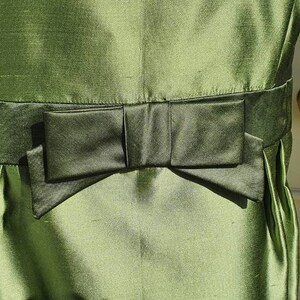 Peut inclure: Une robe verte avec un nœud noir à la taille.