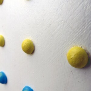Acryl-Flachreliefgemälde von Retro-Candy-Buttons, blaue und gelbe Punkte auf Weiß, eingerahmt in Schwarz, Pop-Art