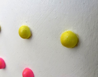 Acrylic low relief painting of retro candy buttons, pink and yellow dots on white, framed in black, pop art