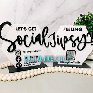 May include: Two white hexagonal signs with black lettering. The sign on the left says "Let's Get Social Jupsy" with social media icons and the text "@Tipsytrailerllc" and "@tipsy-trailer llc mobile bar". The sign on the right says "Feeling Social Jupsy" with a Venmo QR code and the text "@tipsytrailerllc".