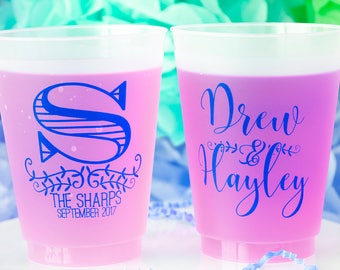 May include: Two pink plastic cups with blue text. One cup says "Drew & Hayley" and the other cup says "S The Sharps September 2017".
