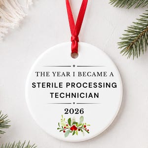 May include: A round white ceramic ornament featuring a red ribbon for hanging. The text reads THE YEAR I BECAME A STERILE PROCESSING TECHNICIAN followed by 2026 and a small illustration of green holly leaves with red berries at the bottom center.