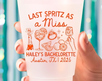 May include: A frosted plastic party cup featuring orange printed graphics of a champagne bottle, a cocktail glass, a diamond ring, and citrus slices. The text reads: LAST SPRITZ AS A MISS, HAILEY'S BACHELORETTE, Austin, TX | 2026.