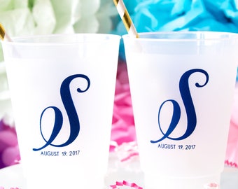 May include: Two white plastic cups with blue cursive letter "S" and the date "August 19, 2017".