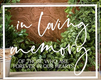 May include: A clear acrylic sign with white lettering that reads "in loving memory of those who are forever in our hearts".