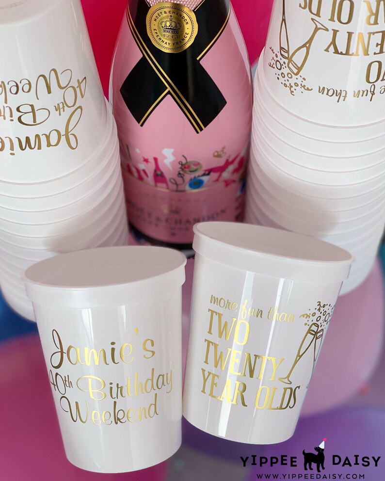 May include: White plastic cups with gold lettering. One cup says "Jamie's 40th Birthday Weekend". Another cup says "More fun than two twenty year olds".