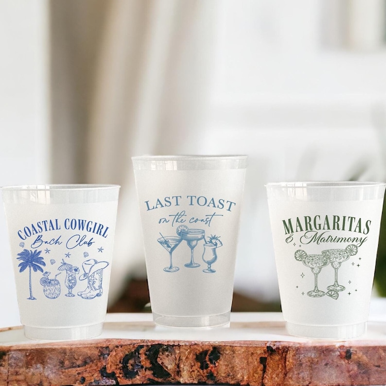 May include: Three clear plastic cups with blue and green designs. The cups have the text "Coastal Cowgirl Bach Club", "Last Toast on the Coast", and "Margaritas & Matrimony".