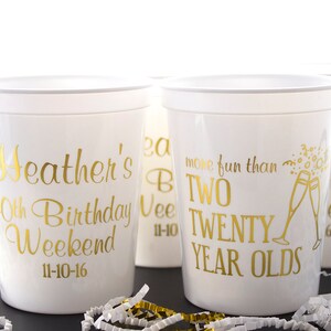 May include: Four white plastic cups with gold lettering. The cups are decorated with the text "Heather's 40th Birthday Weekend 11-10-16", "more fun than two twenty year olds", and "Heather's birthday weekend".