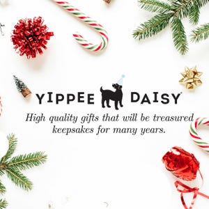 K&ouml;nnte beinhalten: Ein wei&szlig;er Hintergrund mit einer schwarzen Silhouette eines Hundes, der einen Partyhut tr&auml;gt. Der Text "YIPPEE DAISY" befindet sich &uuml;ber dem Hund. Der Text "High quality gifts that will be treasured keepsakes for many years." befindet sich unter dem Hund. Das Bild ist mit rot-wei&szlig;en Zuckerstangen, roten Schleifen und gr&uuml;nen Kiefern&auml;sten verziert.