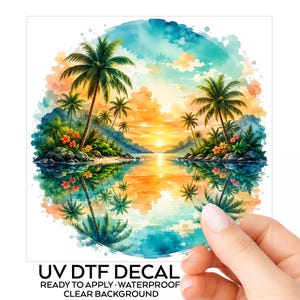 May include: A circular UV DTF decal featuring a vibrant watercolor tropical sunset scene with palm trees, lush foliage, orange flowers, and rocky shores reflected in calm water. The text UV DTF DECAL READY TO APPLY WATERPROOF CLEAR BACKGROUND is below.