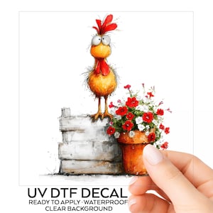 May include: A UV DTF decal featuring a cartoon chicken with wide eyes and a red comb standing on a gray wooden crate next to a terracotta pot filled with red and white flowers. The text reads UV DTF DECAL READY TO APPLY WATERPROOF CLEAR BACKGROUND.