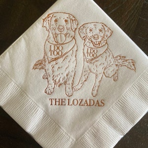 May include: Two golden retriever dogs wearing bandanas with the text "I do too" on a white napkin with the text "The Lozadas" printed below.