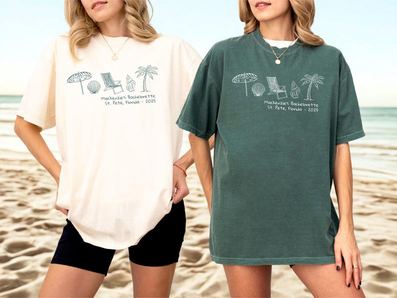 May include: Two women wearing oversized t-shirts. One is cream-colored, the other is dark green. Both shirts feature a beach-themed graphic and the text "Mackenzie's Bachelorette St. Pete, Florida - 2025". The shirts are paired with black shorts.