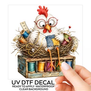 May include: A UV DTF decal featuring a white chicken with a red comb wearing red glasses, sitting in a nest while sewing a blue and yellow patch. The nest rests on a wooden box labeled FANCY SPOOLS containing colorful thread spools and measuring tapes.