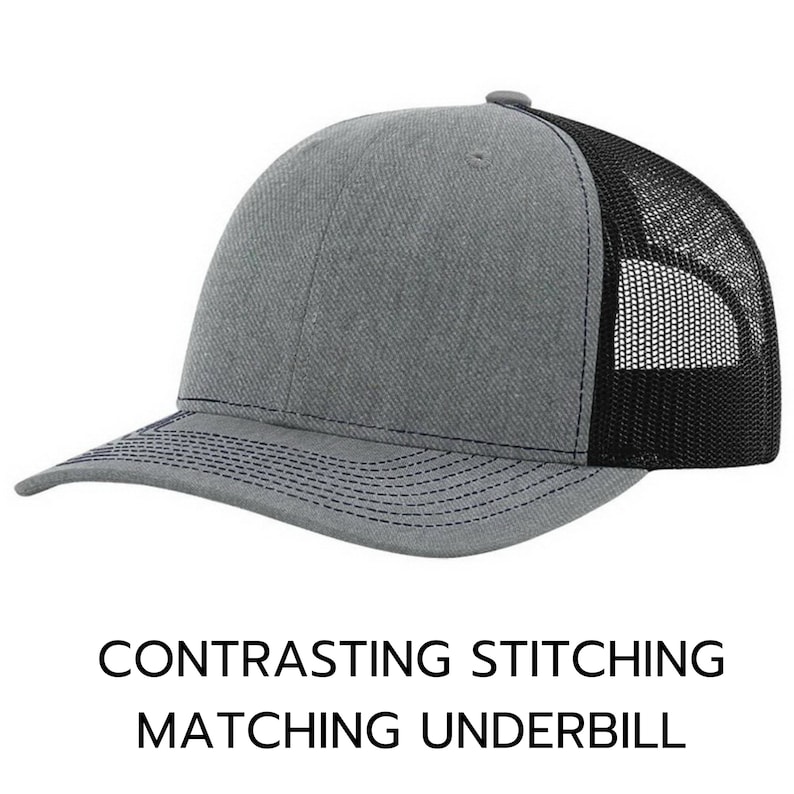 May include: A gray and black trucker hat with a contrasting navy blue stitching detail. The hat has a mesh back and a solid front panel.