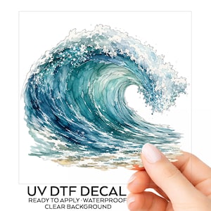 May include: A UV DTF decal featuring a watercolor illustration of a large ocean wave in shades of deep blue, teal, and white sea foam. The design is printed on a clear background with the text UV DTF DECAL READY TO APPLY WATERPROOF CLEAR BACKGROUND.