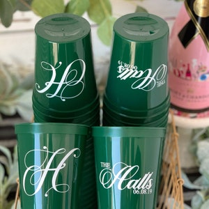 Puede incluir: Pila de vasos de pl&aacute;stico verde con letras blancas. El vaso de arriba dice "The Halls 06.08.19".