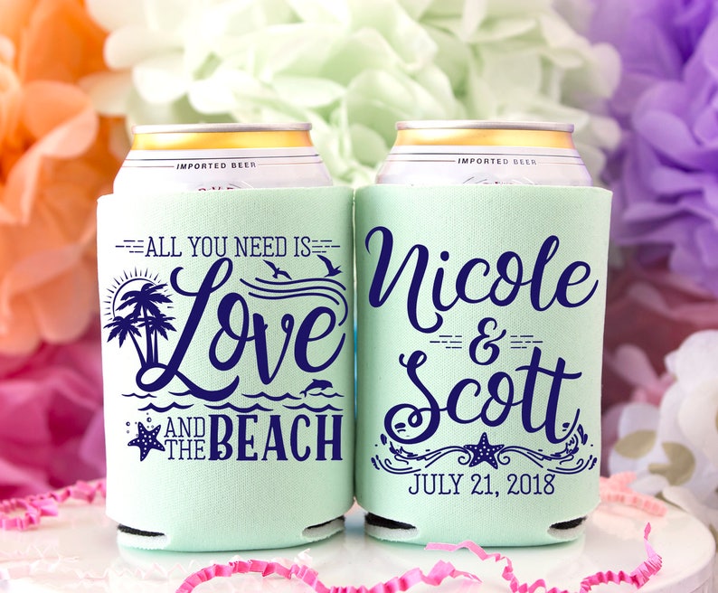 May include: Two mint green can coolers with blue text. One cooler says "All you need is Love and the Beach" with a palm tree and starfish design. The other cooler says "Nicole & Scott" with the date "July 21, 2018" and a starfish design.