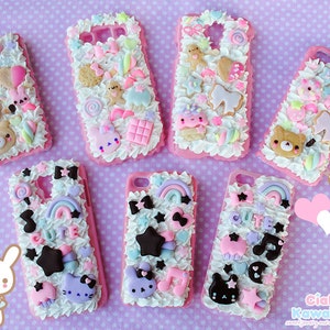 May include: Seven pink and white phone cases decorated with colourful 3D embellishments, including candy, stars, rainbows, and cartoon characters. The cases are made of a soft, squishy material and have a fluffy, cloud-like texture.