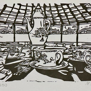 May include: Black and white linocut print depicting a tea set with a teapot, cups, and saucers on a table. The print includes the text "1/250" and the artist's signature. The scene is set indoors with a window in the background.