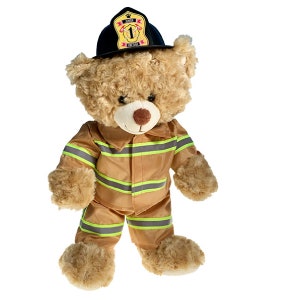 Puede incluir: Un oso de peluche marrón que lleva un sombrero de bombero negro con un parche amarillo que dice "Junior Fire Chief" y un uniforme de bombero a rayas amarillas y negras.
