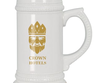 Puede incluir: Jarra de cerveza de cerámica blanca con ribete dorado y un logotipo dorado de un rostro de rey con una corona y el texto "CROWN HOTELS".