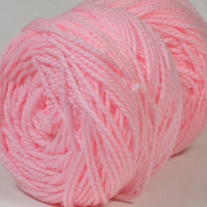 May include: A ball of soft, pink yarn. The yarn is wound into a tight coil.