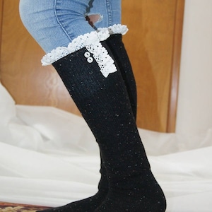 May include: Black knee-high socks with white lace trim and buttons. The socks are worn with blue jeans.