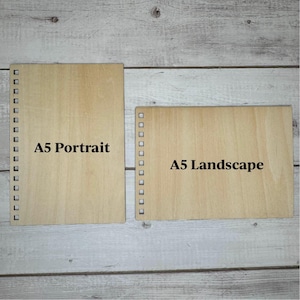 May include: Two wooden boards with a hole pattern around the edges. The board on the left is labeled "A5 Portrait" and the board on the right is labeled "A5 Landscape".