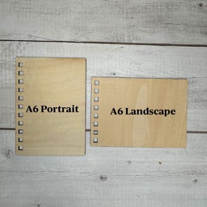 May include: Two pieces of wood, one labeled "A6 Portrait" and the other "A6 Landscape".